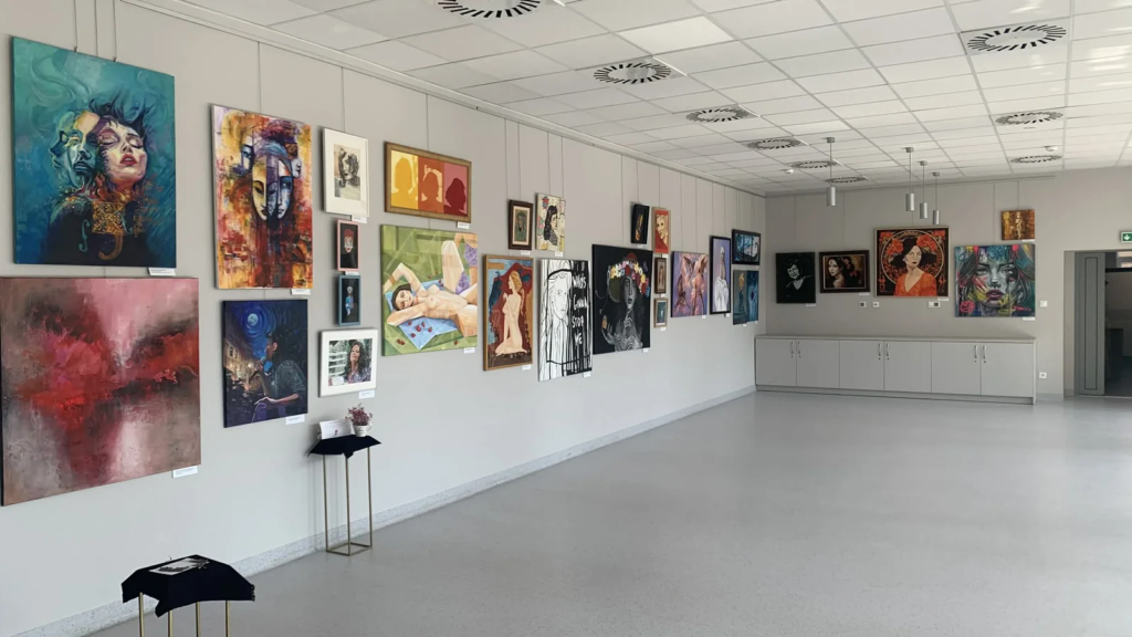 Wielogłos wśród prac innych autorów na ścianie galerii