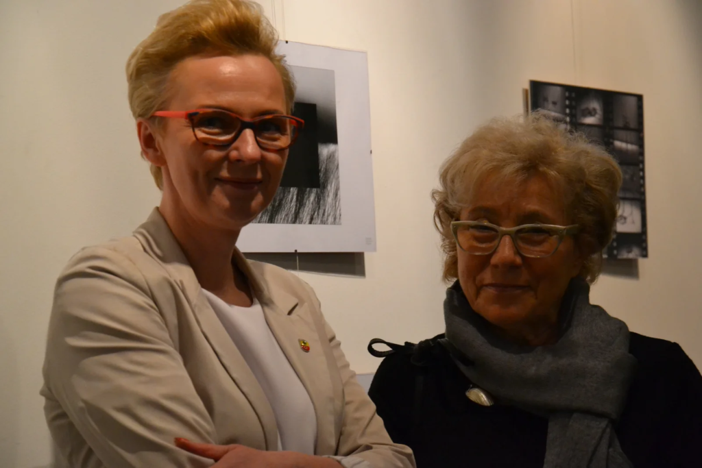 Dwie uczestniczki wernisażu na tle ilustracji, wystawa ilustracji Laboratorium ArtDHD, Miejskie Centrum Kultury, Czarnków 2015