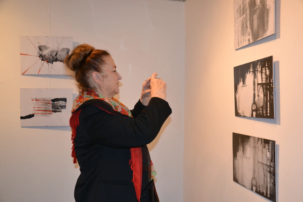 Zwiedzająca fotografuje ilustracje na ścianie, wystawa ilustracji Laboratorium ArtDHD, Miejskie Centrum Kultury, Czarnków 2015