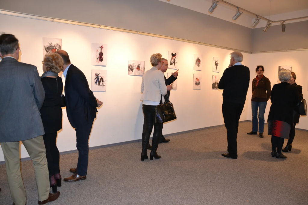 Goście oglądają ilustracje w sali galerii, wystawa ilustracji Laboratorium ArtDHD, Miejskie Centrum Kultury, Czarnków 2015