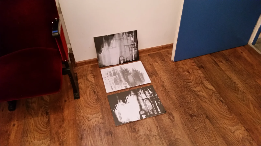 Prace oparte o ścianę i rozłożone na podłodze podczas montażu, wystawa ilustracji Laboratorium ArtDHD, Galeria Sztuki TAŚMA, Poznań 2015