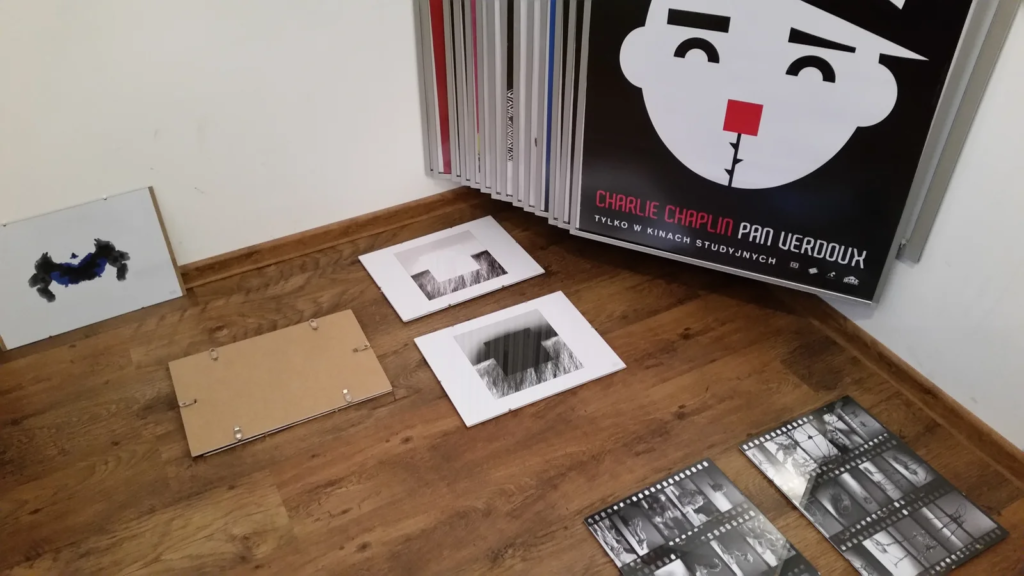 Duży plakat filmowy i ilustracje rozłożone na podłodze podczas montażu, wystawa ilustracji Laboratorium ArtDHD, Galeria Sztuki TAŚMA, Poznań 2015