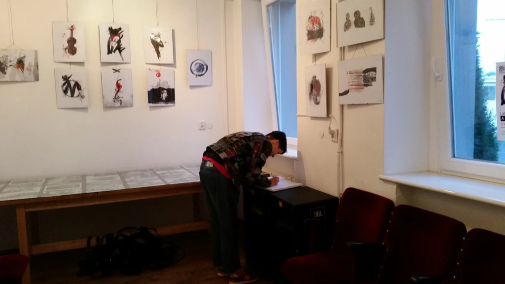 Angelina wpisuje się do księgi gości, wystawa ilustracji Laboratorium ArtDHD, Galeria Sztuki TAŚMA, Poznań 2015